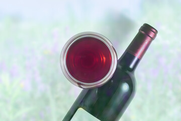
Glass and bottle of red wine on pastel cold background