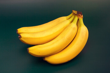 bunch of bananas on a dark green background