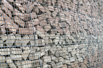 Stone wall of concrete bricks and mesh.