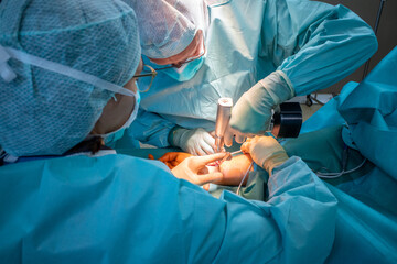 2 doctors operate on a wrist fracture in an operating theatre