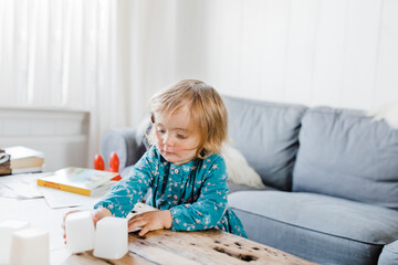 Toddler girl playing with plastic containers on table