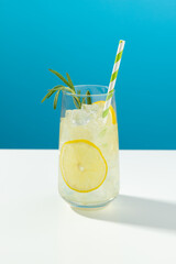 Glass ice lemonade with rosemary on blue background