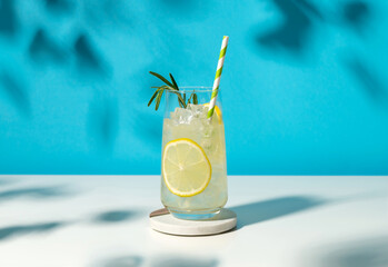 Glass ice lemonade with rosemary on blue background