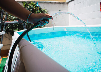 Woman filling pool with water