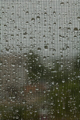Many drops of water from the rain on the mesh surface