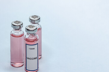 Vaccine in glass bottles on a white background. Three vials with one dose of vaccine.