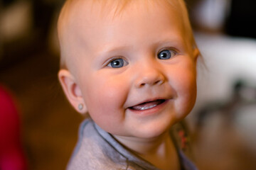 portrait of a smiling baby, european 
girl with blue eyes.