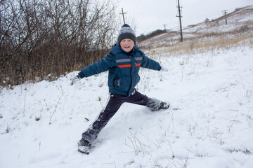 Fototapeta na wymiar sits twine on the snow,boy goes in for sports in the snow in winter