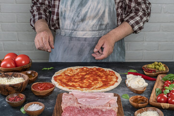 Pizza preparation with chef hands. Pizza making process decorating pizza