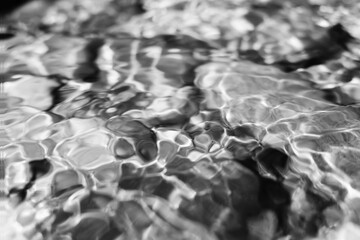 Black and white reflections on the water surface, smooth surface with bubble and circular patterns....