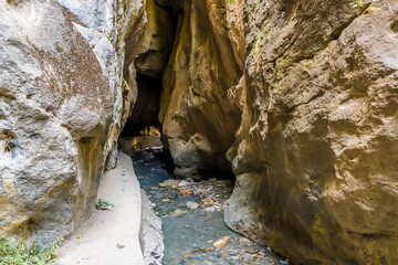 A view of the Monachil river entering a tunnel in the Sierra Nevada mountains, Spain in the summertime