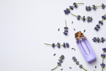 Composition with lavender flowers and natural essential oil on white background, top view