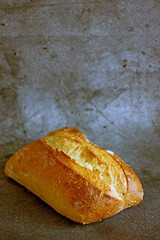 Loaf of sourdough craft bread on a dark background close-up, vertical background