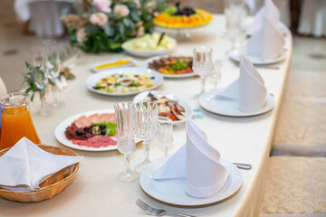 Tasty dishes on a served white banquet table in a luxury restaurant.