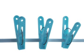  A group of blue clothespin hanging on a metal line ,white isolated background with copy space and day light