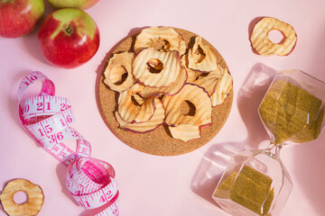 Organic apple chips, cinnamon and star anise on a pink background. Healthy vegan vegetarian fruit snacks. Natural food for wellness. Time to lose weight