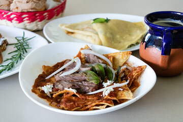 Traditional mexican breakfast dishes including chilaquiles, crepas and sweet bread
