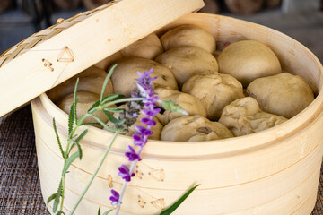 Japanese Nikuman dumplings in a bamboo steamer with lavender