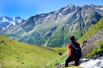 Tourist standing back over beautiful view on caucasian mountains and blue sky in summer. Nature of the Elbrus region. - 370820853