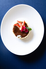 Delicious chocolate and strawberry tart top view in white plate