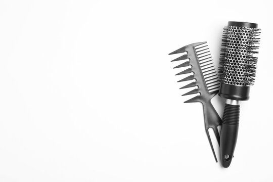 Modern hair comb and round brush on white background, top view