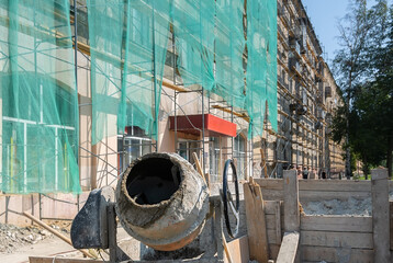 an industrial construction concrete mixer and a box of cement stand on the street against the...