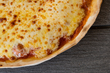 Corner of freshly baked cheese pizza