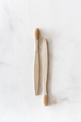 Composition with biodegradable bamboo toothbrushes on marble background. Sustainable, zero waste, plastic free, lifestyle concept. Eco-friendly oral hygiene accessories.Flat lay, top view, copy space.