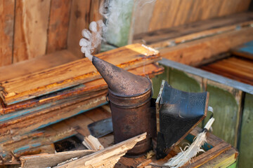 The apiary smokes. Ready to work. Next to it are dry firewood.