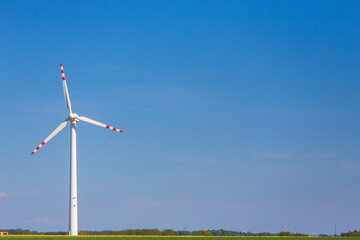 Turbina wiatrowa ekologicznego źródła energii na tle niebieskiego nieba. - obrazy, fototapety, plakaty