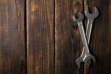 Mechanic wrenches on wooden background, space for text