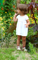 a little girl walks in the garden