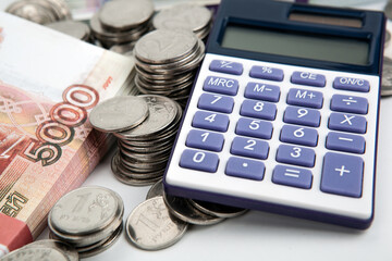 a bundle of 5000 rubles banknotes and many Russian coins and calculator