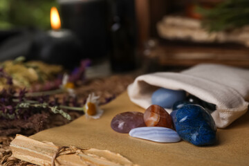 Bag with gemstones and healing herbs on table