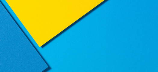 Abstract color papers geometry flat lay composition banner background with yellow and blue tones