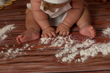 the child holds a rolling pin for the dough