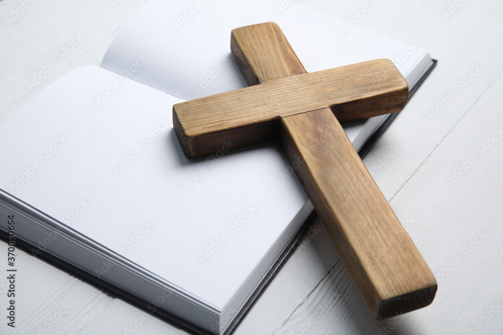 Wall mural Christian cross and Bible on white wooden background, closeup. Religion concept