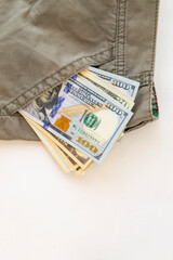 Money in a pocket of trousers or a skirt on a white background. Copy space. The concept of buying for dollars
