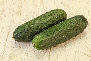 Green fresh cucumbers over background