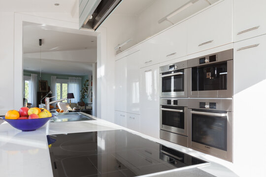 Interior of contemporary kitchen with high tech furniture and appliances in apartment during daytime