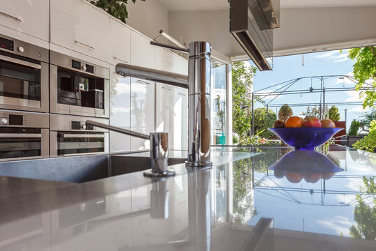 Interior of contemporary kitchen with high tech furniture and appliances in apartment during daytime