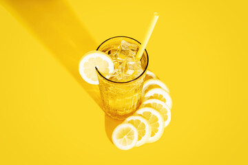 From above glass of fresh beverage with lemons and kiwi placed on table in studio