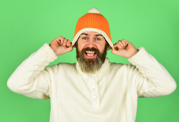 Fototapeta premium Feeling good. Bearded hipster. Hipster style. Head in warm hat. Handsome man knitted hat with pom pom. Fashion concept. Winter clothes and accessories. Mature emotional hipster funny style accessory