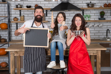 Parents mom dad and daughter chalkboard at kitchen, baking cake concept