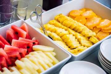 High angle of slices of fresh watermelon and melon placed on table with pieces of oranges and pineapples
