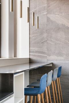 Modern bright interior with high ceilings furnished with design lamps and stools placed next to windows