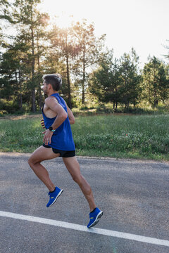Determined man running on road during workout