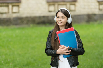 Fototapeta premium Schoolgirl listening audio books on way to school, audio lessons concept