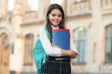 Little girl student school uniform and backpack hold books, formal education concept