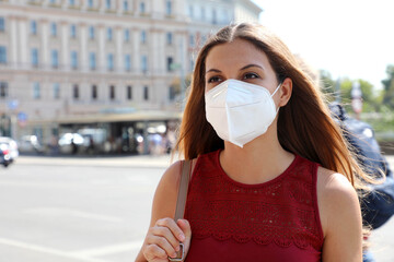 COVID-19 Woman walking in city street wearing KN95 FFP2 mask protective for spreading of disease...